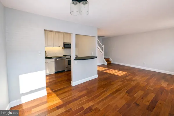 a view of a kitchen with wooden floor and electronic appliances