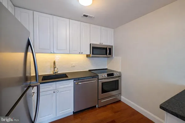 a kitchen with a sink stove and microwave