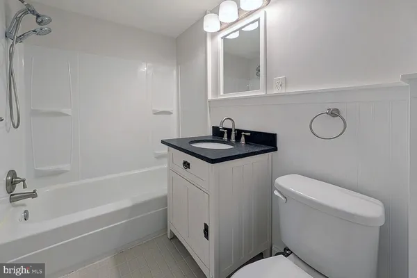 a bathroom with a granite countertop toilet a sink and bathtub