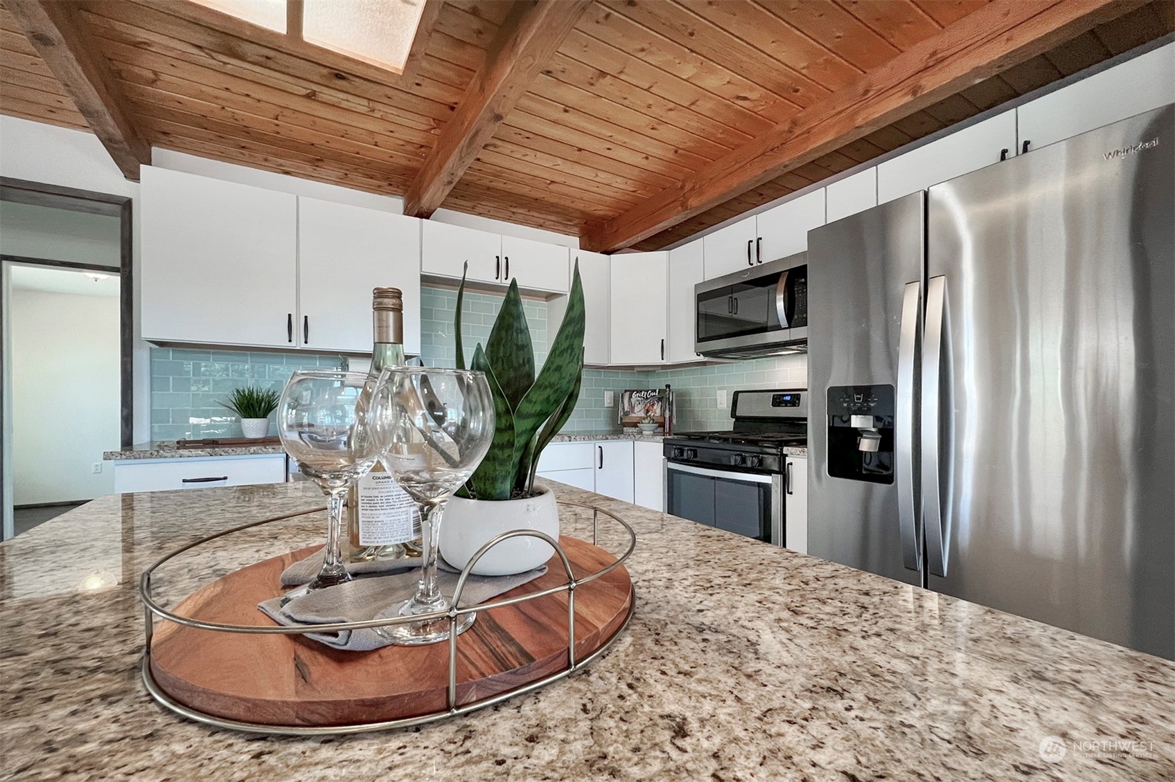 220 East Olympic Drive Grapeview, WA 98546 - Photo 16 of 40 a kitchen with stainless steel appliances granite countertop a refrigerator a stove a sink a dining table and chairs with wooden floor