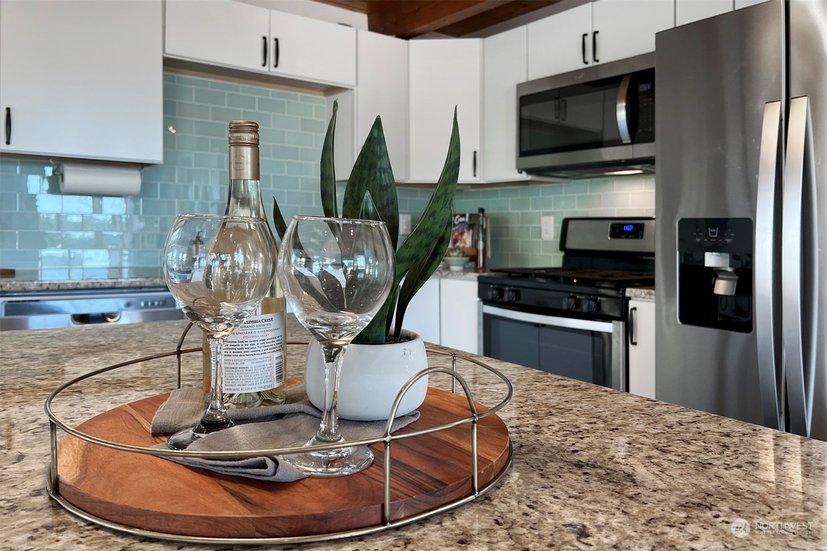220 East Olympic Drive Grapeview, WA 98546 - Photo 20 of 40 a kitchen with stainless steel appliances a dining table a microwave a refrigerator and cabinets