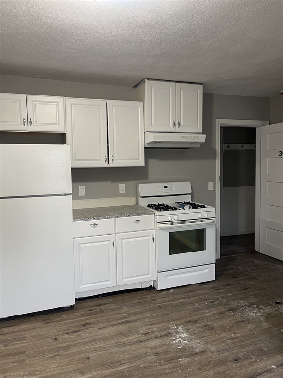 8 Wakefield Avenue, Unit 3R Wakefield, MA 01880 - Photo 2 of 7 a kitchen with granite countertop white cabinets and white appliances