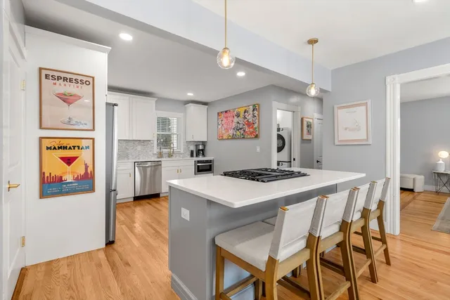 a kitchen with stainless steel appliances granite countertop a stove a refrigerator a oven a sink with island chairs and wooden floor