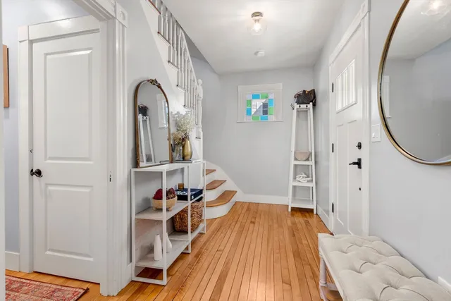 a view of a hallway with wooden floor and staircase