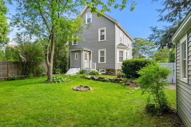 a view of a house with backyard and sitting area