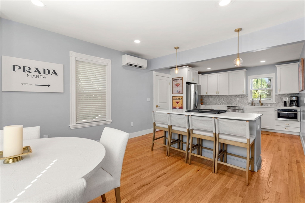 26 Clark Street Danvers, MA 01923 - Photo 9 of 42 a kitchen with kitchen island a dining table and chairs in it