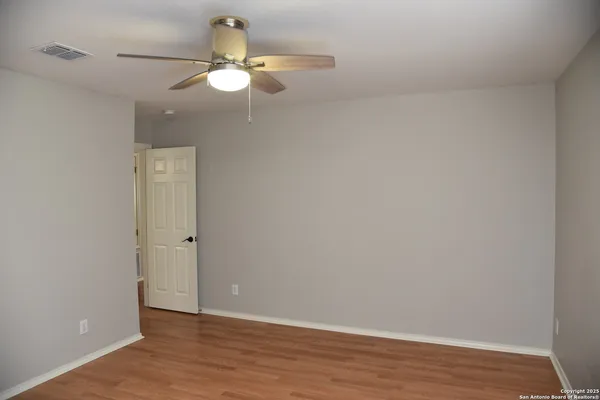 a view of an empty room with wooden floor