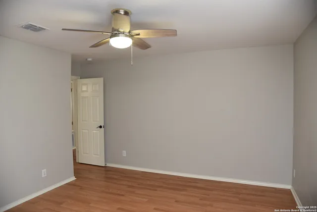 a view of an empty room with wooden floor