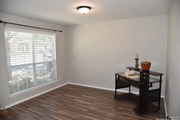 a view of a workspace with wooden floor and a window