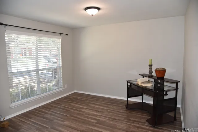 a view of a workspace with wooden floor and a window