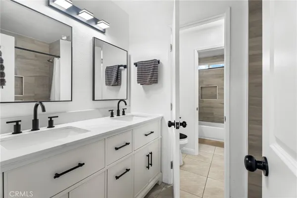 a bathroom with a double vanity sink mirror and shower