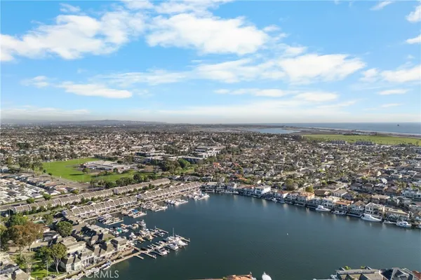 an aerial view of ocean and residential houses with outdoor space