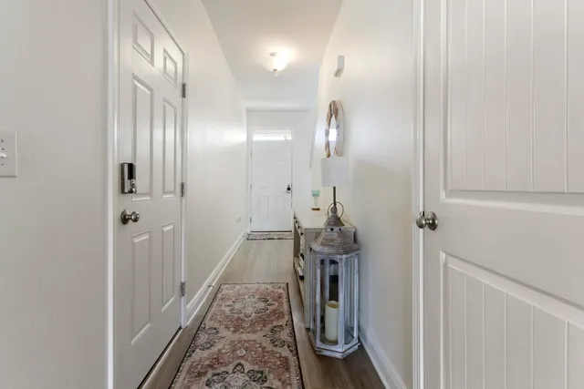 a view of a hallway with wooden floor and staircase