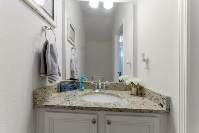 a bathroom with a granite countertop sink and a mirror