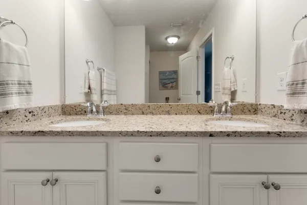 a bathroom with a granite countertop sink and a mirror