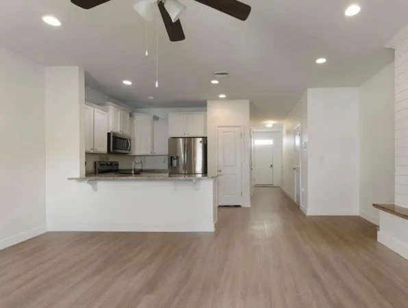a view of kitchen with stainless steel appliances refrigerator stove microwave and cabinets
