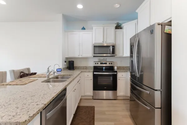 a kitchen with stainless steel appliances granite countertop a refrigerator stove and sink