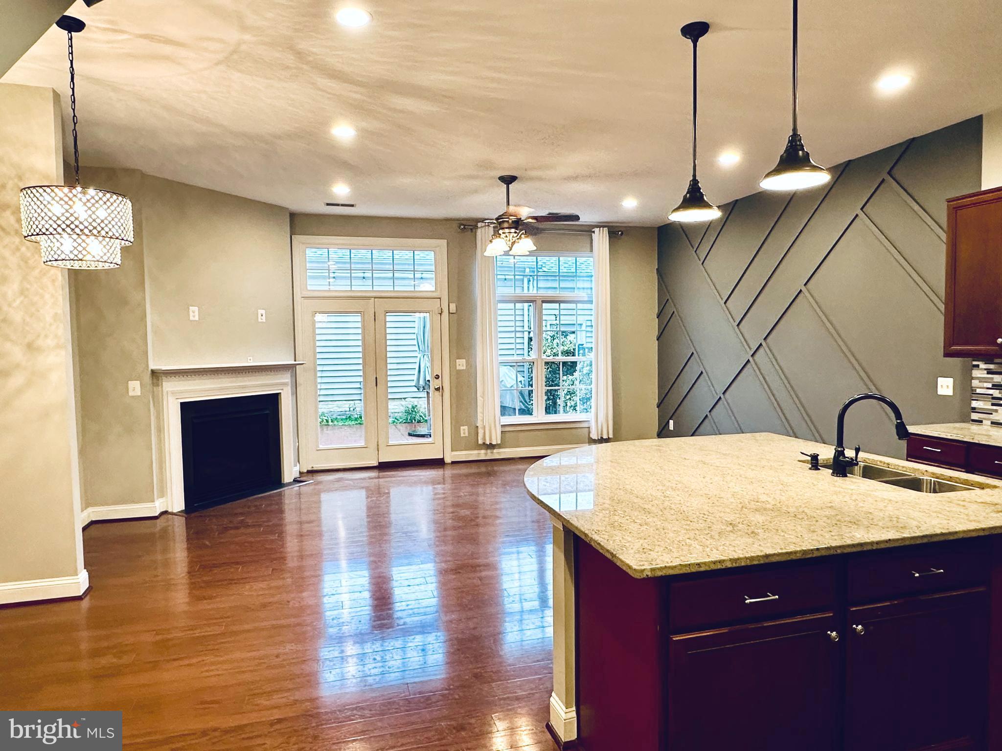 9032 Ribbon Falls Loop Bristow, VA 20136 - Photo 10 of 31 a kitchen with kitchen island a sink appliances and a living room