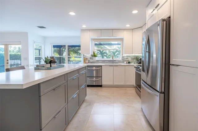 a kitchen with a sink refrigerator and cabinets