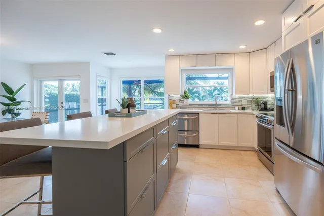a kitchen with stainless steel appliances granite countertop a sink counter space cabinets and a large window