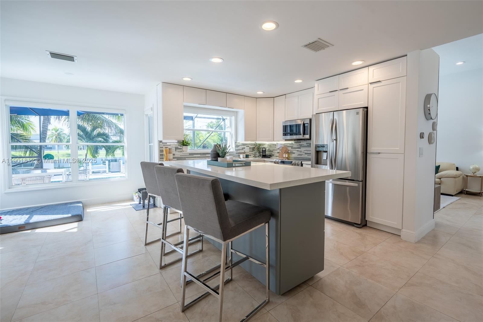 18004 Southwest 20th Street Miramar, FL 33029 - Photo 19 of 49 a kitchen with stainless steel appliances a dining table chairs refrigerator and sink
