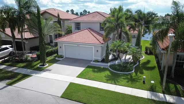 a front view of a house with garden and yard