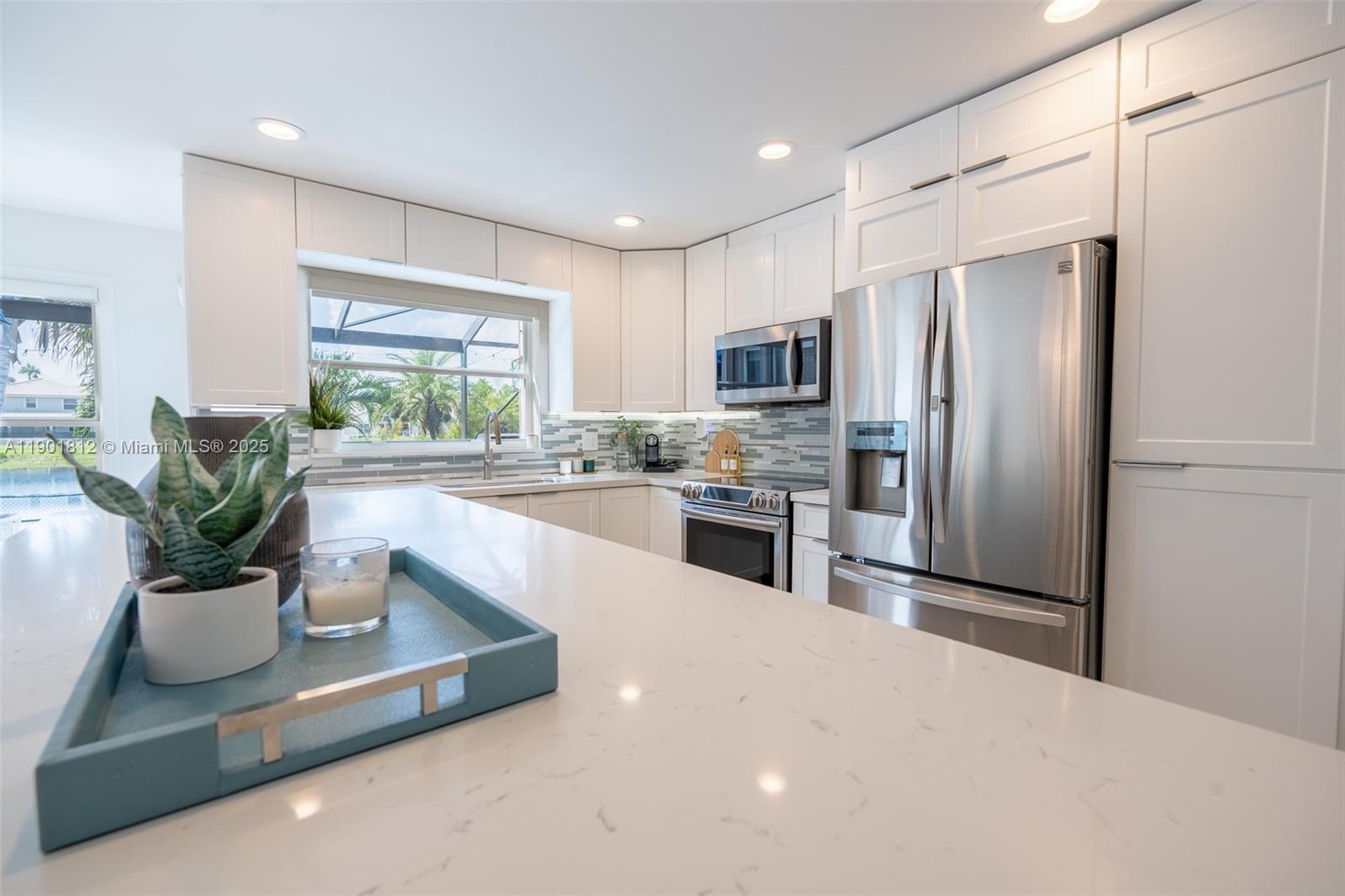 18004 Southwest 20th Street Miramar, FL 33029 - Photo 21 of 49 a kitchen with stainless steel appliances a refrigerator a sink a stove a microwave a dining table and chairs