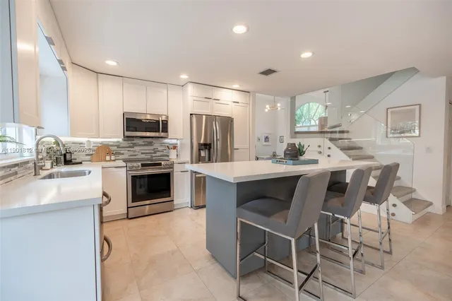 a kitchen with stainless steel appliances a stove a sink refrigerator and a microwave