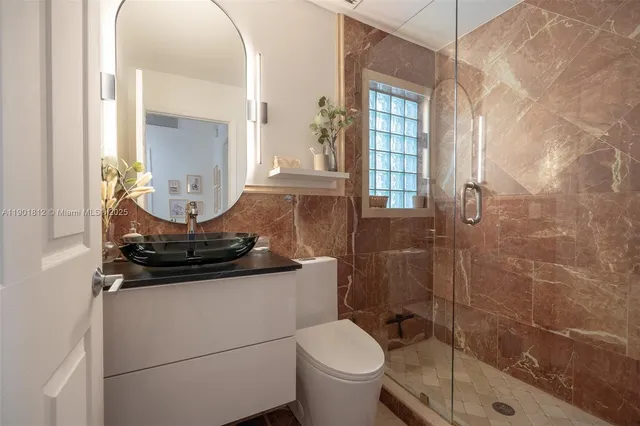 a bathroom with a sink a toilet and shower