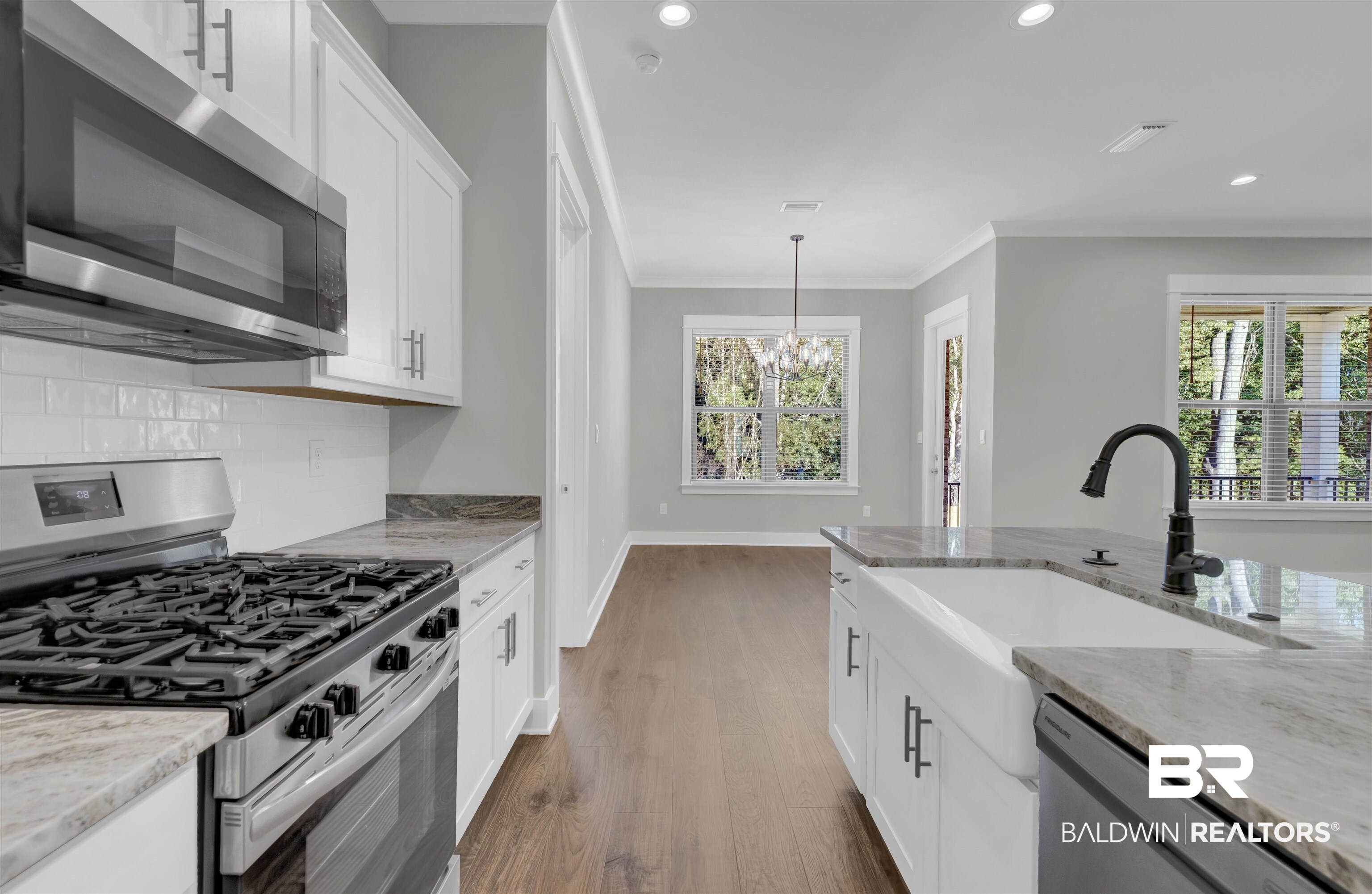571 Morning Mist Way Fairhope, AL 36532 - Photo 7 of 47 Kitchen with stainless steel appliances, light stone counters, white cabinets, hanging light fixtures, and recessed lighting