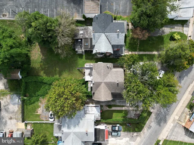an aerial view of residential house with outdoor space and trees all around