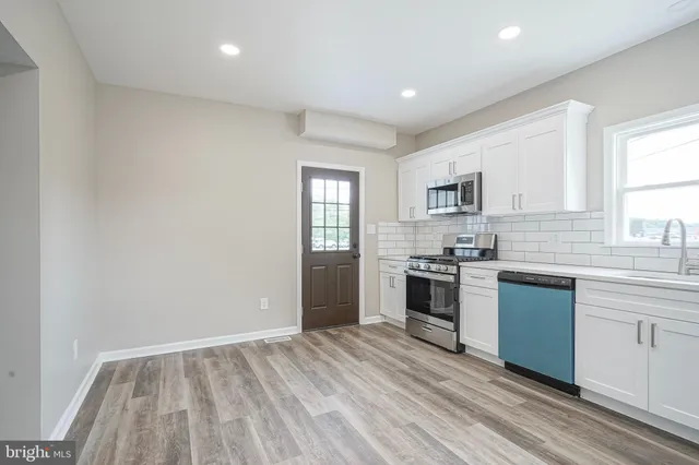 a kitchen with a stove a sink and a microwave
