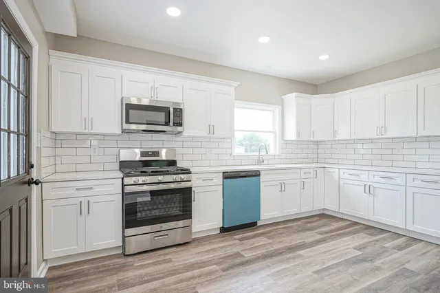 a kitchen with cabinets stainless steel appliances and a window