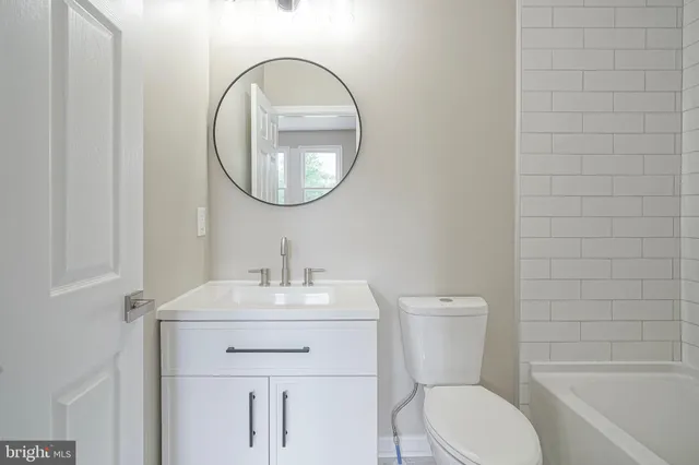 a bathroom with a sink toilet and a mirror
