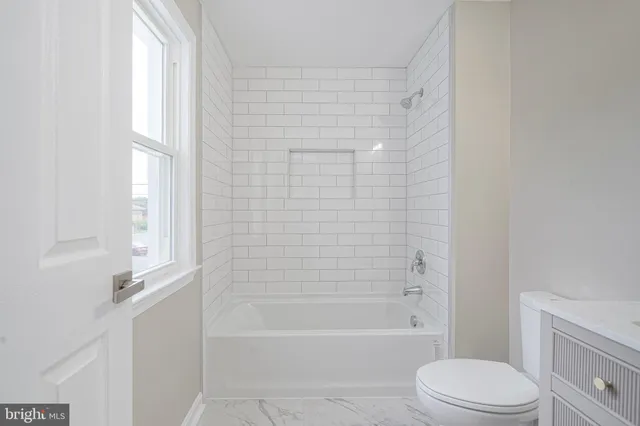 a bathroom with a toilet and a bathtub