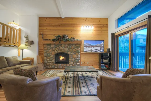 a living room with furniture a large window and a fireplace