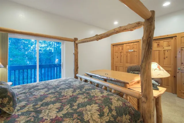 a bedroom with a bed and large window with balcony view