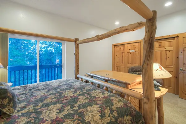 a bedroom with a bed and large window with balcony view