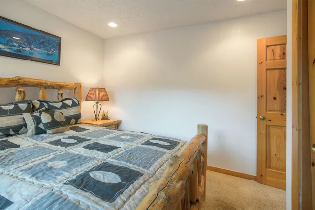 a bed sitting in a bedroom next to a bathroom