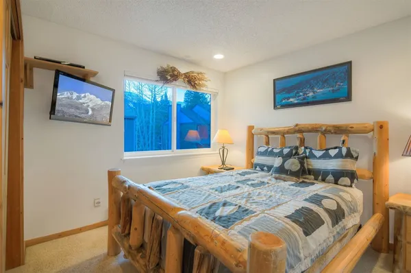 a bedroom with a bed and painting on the wall