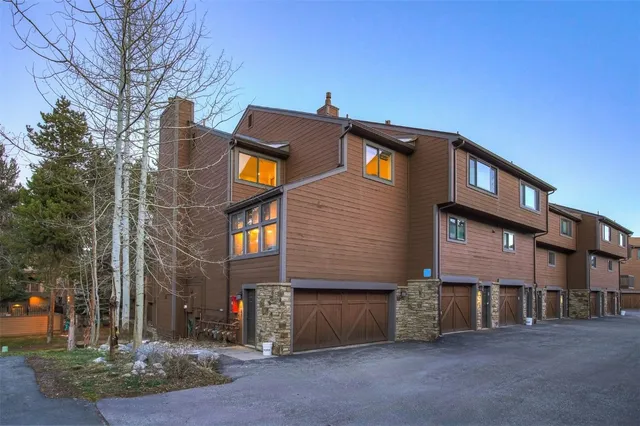 a view of a brick house with large windows and a yard