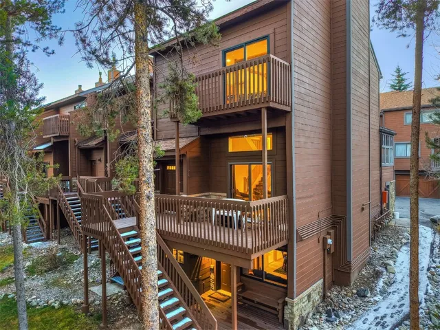 a view of a brick house with many windows and plants