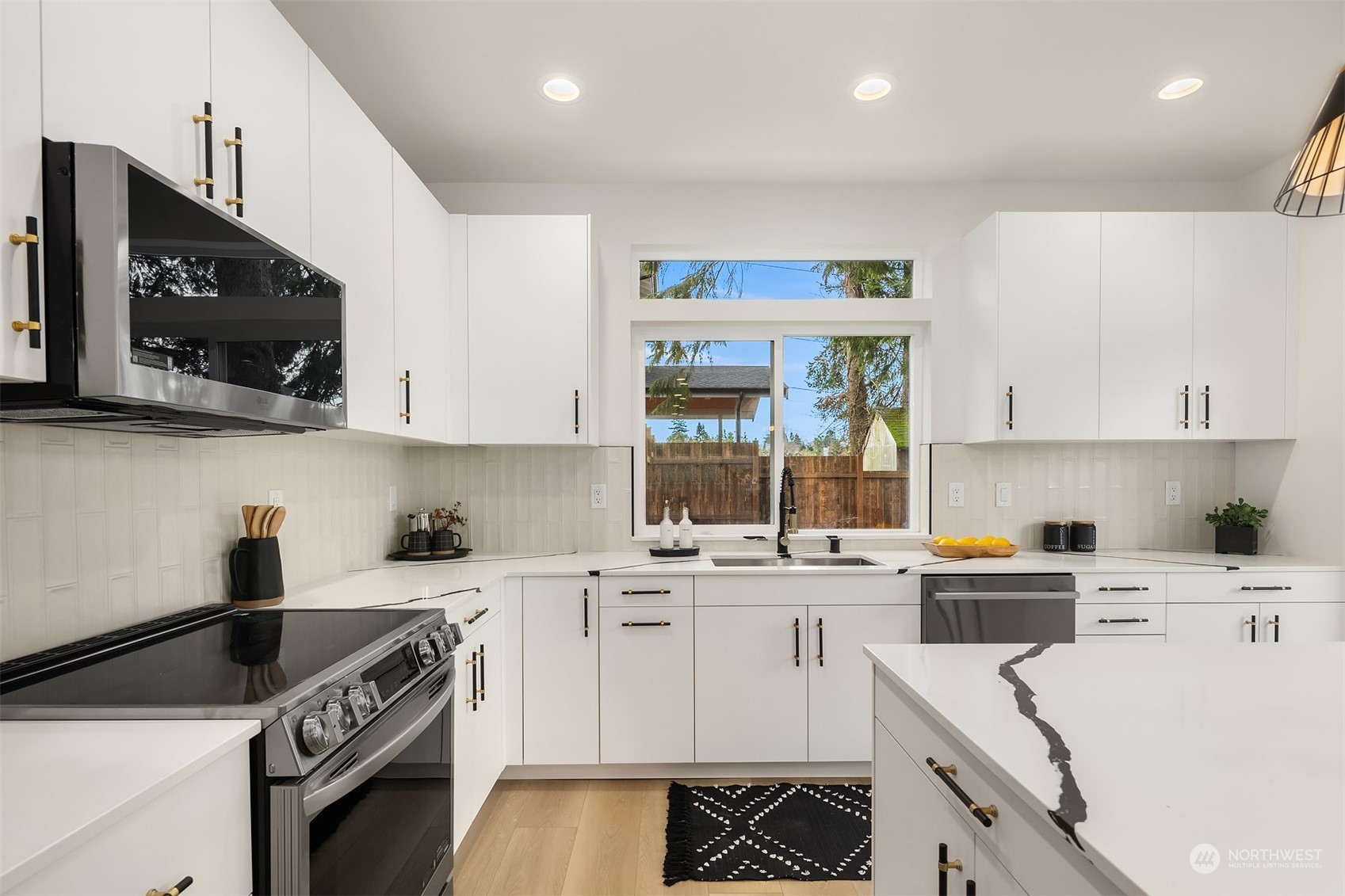 3304 49th Avenue Southwest Seattle, WA 98116 - Photo 11 of 34 a kitchen with a sink a stove and cabinets