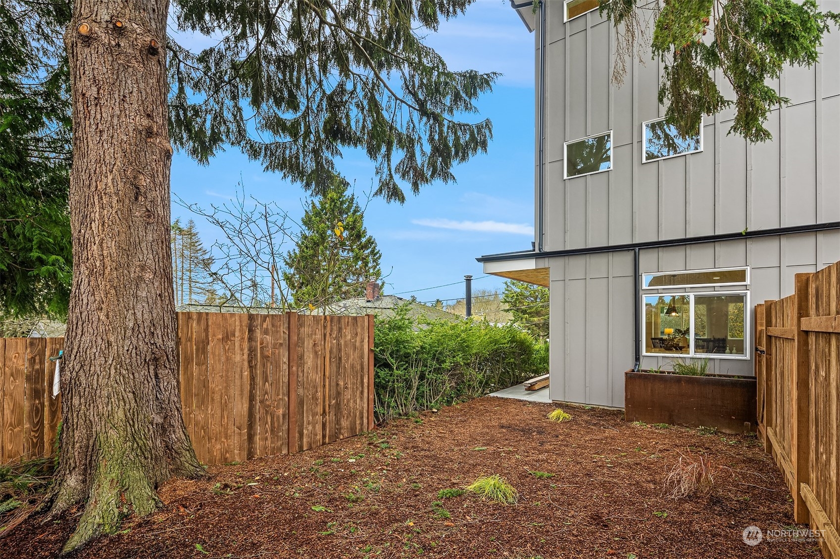 3304 49th Avenue Southwest Seattle, WA 98116 - Photo 28 of 34 a view of a house with a tree in front of it