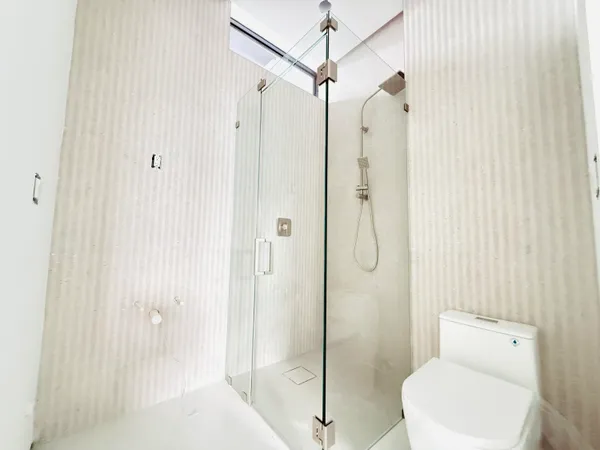 a bathroom with a shower a toilet and a sink