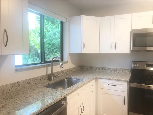 a kitchen with granite countertop a sink and a window