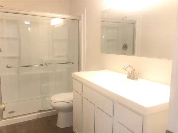 a bathroom with a sink a toilet and shower
