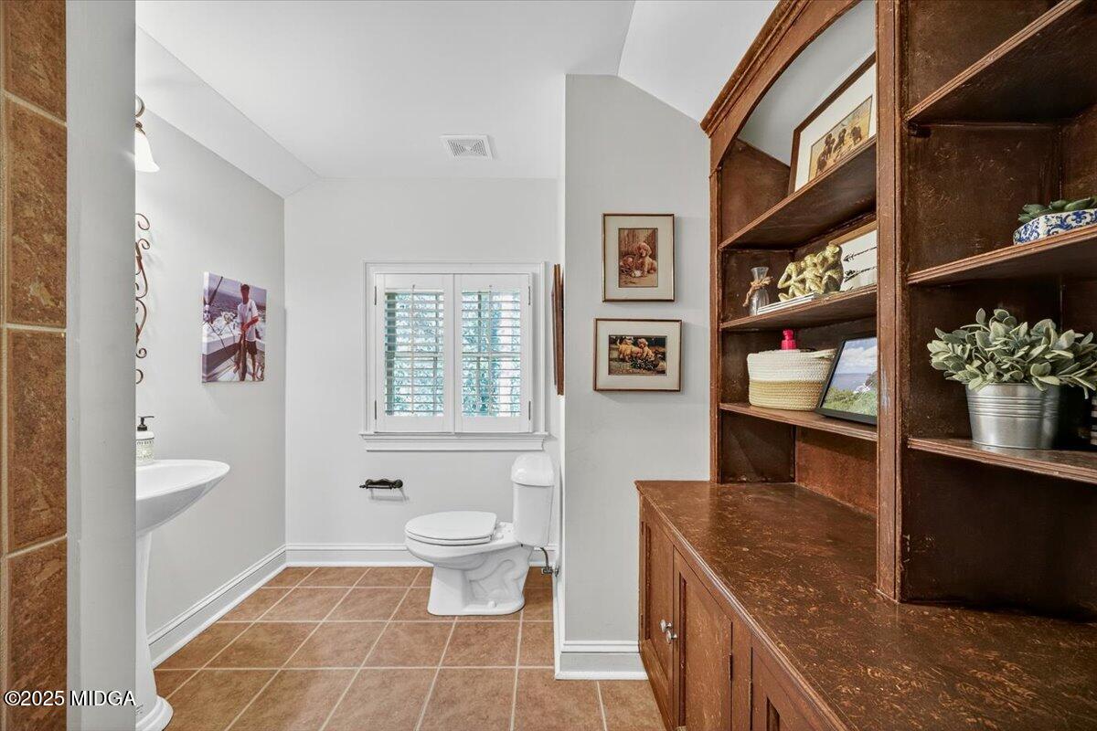 1158 Jackson Springs Road Macon, GA 31211 - Photo 32 of 42 a spacious bathroom with a granite countertop sink a toilet and a shower
