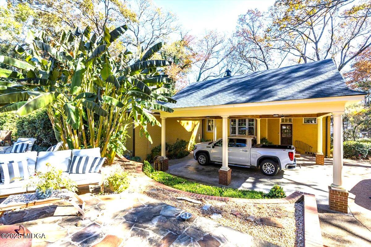 1158 Jackson Springs Road Macon, GA 31211 - Photo 40 of 42 a view of a patio with couches table and chairs under an umbrella with large trees