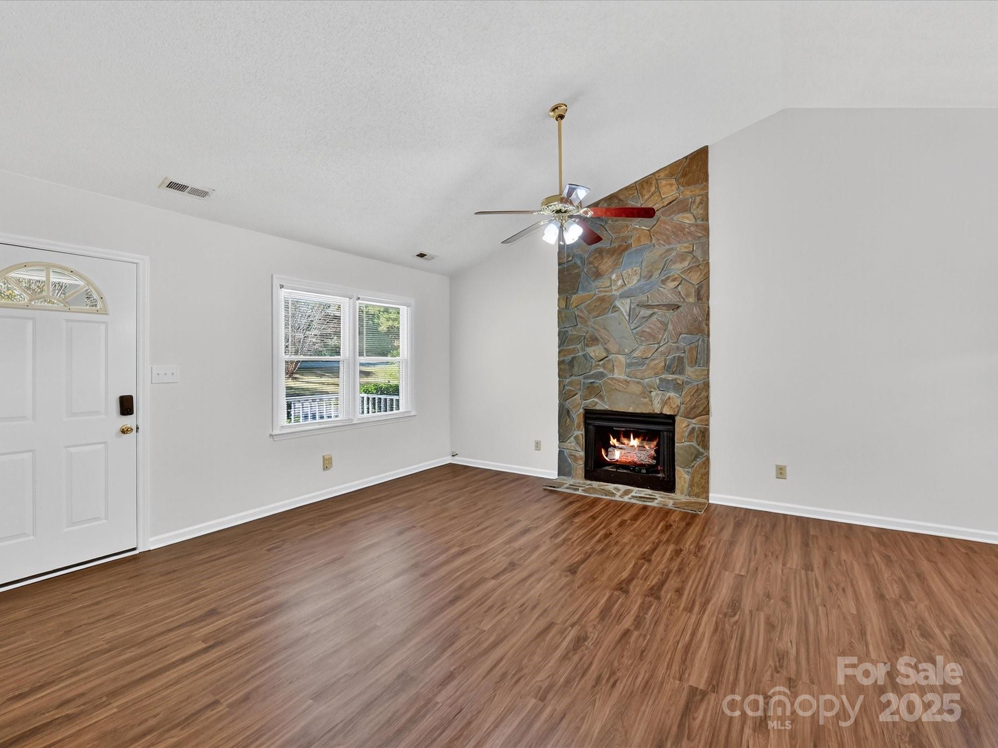 2407 Ruben Road Monroe, NC 28112 - Photo 6 of 33 a view of an empty room with wooden floor fireplace and a window